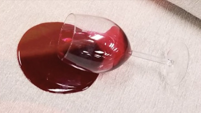 a glass of red wine spilled on a carpet
